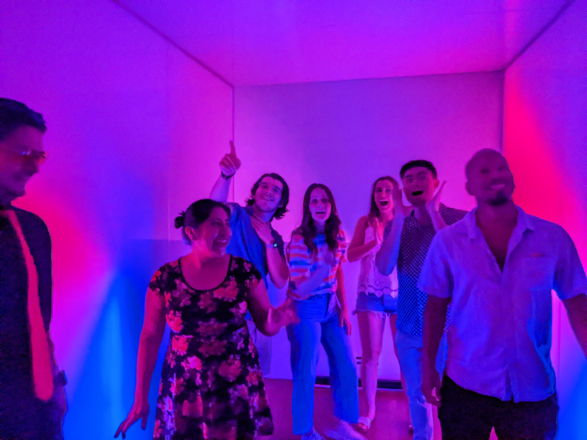 Group of people having fun in the Eureka Room with purple lighting